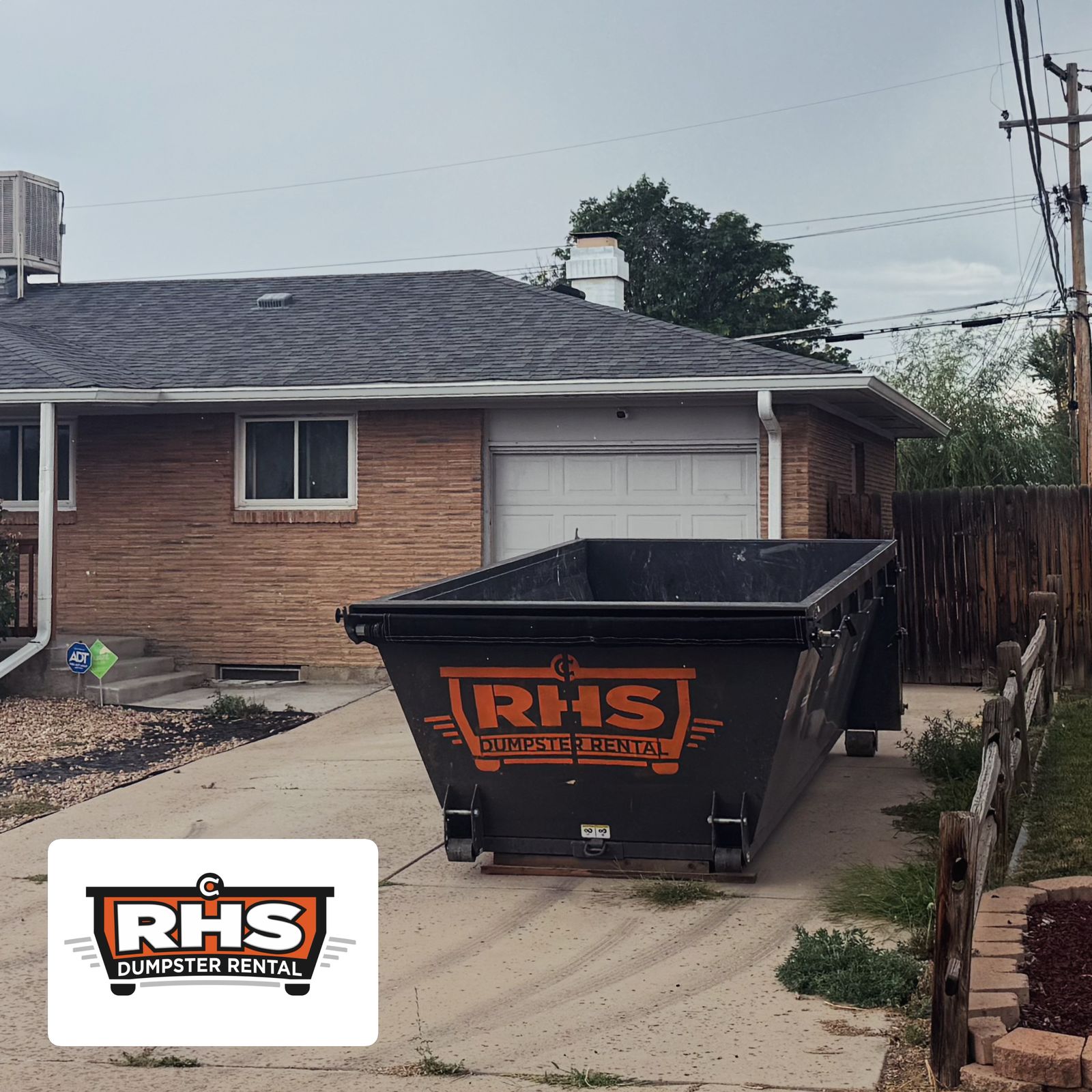15-yard RHS dumpster delivered to a brick home's driveway